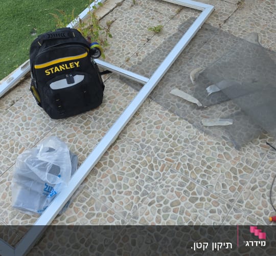 מסגרת חלון וכלי עבודה על רצפת אבן